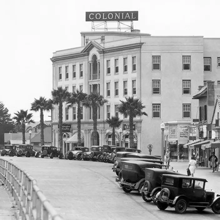 Old-Grand-Colonial-1 An old photograph in black and white of the Colonial Hotel building with multiple old vehicles parked in the street