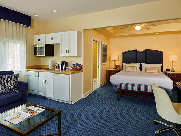 offers-free-suite-upgrade A suite with a king-sized bed, a mini kitchen with a table and sitting area