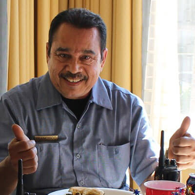 A man in front of a table holding two thumbs up