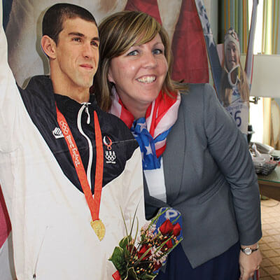 A woman standing next to a cardboard cutout of a person