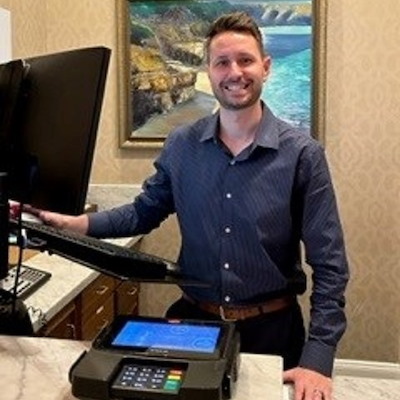 A man standing at the front desk of the hotel