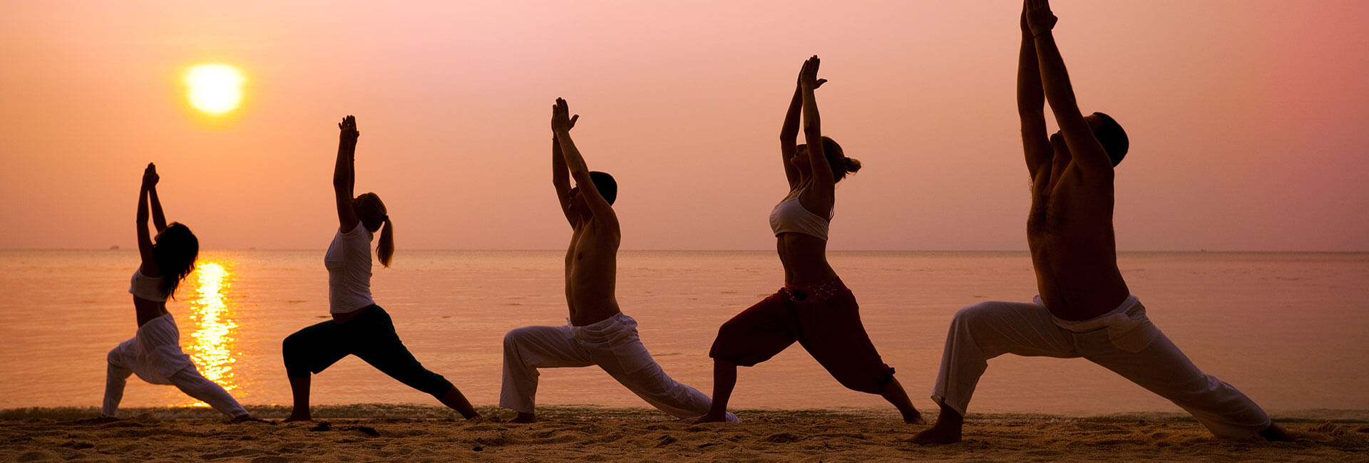 people doing yoga on the beach