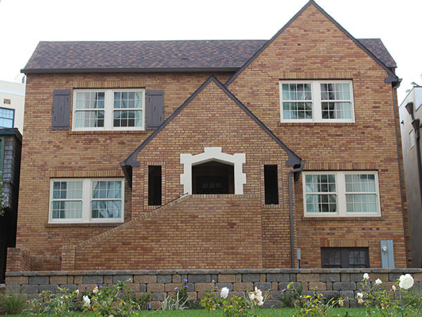 vacation-rentals-tudor-1-bedroom-king-suite A red brick Tudor-style house with two floors and a staircase leading to the front door.