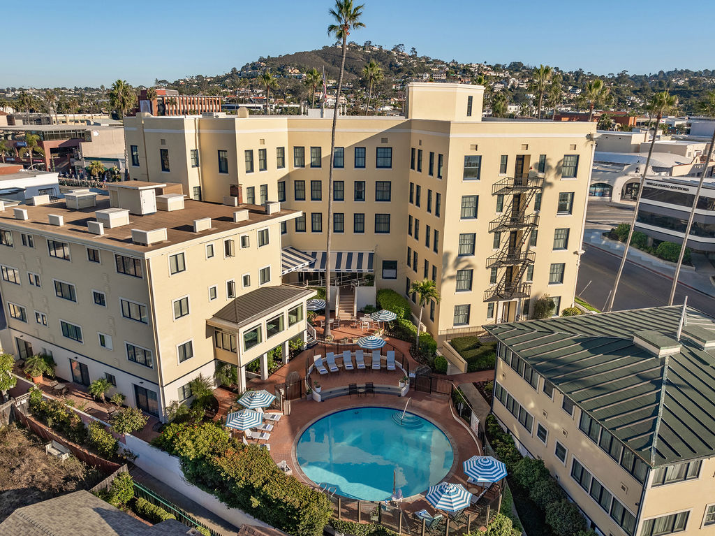 aerial photo of back side of hotel and swimming pool