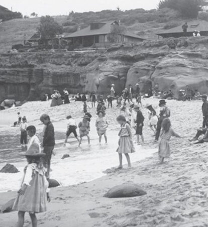 old black and white photo of children playing on a beach