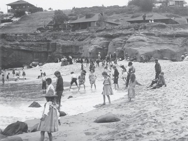 old black and white photo of children playing on a beach