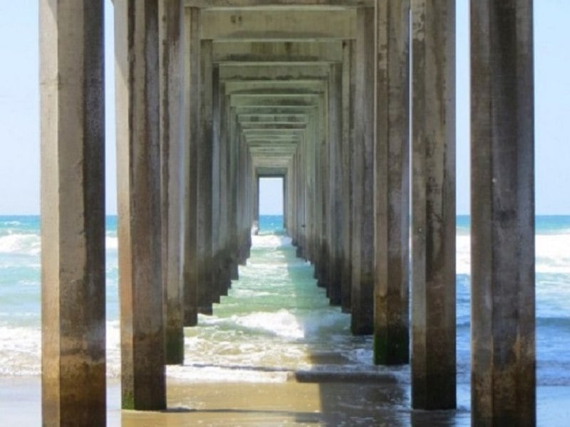 waves approaching beach under pier