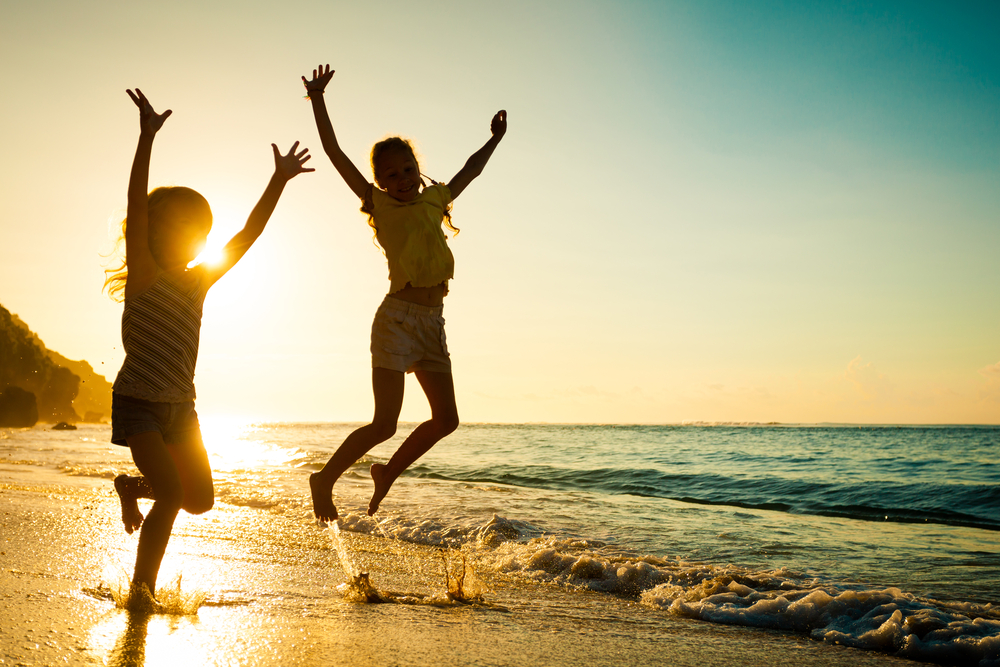 Kids Jumping in Waves on Beach