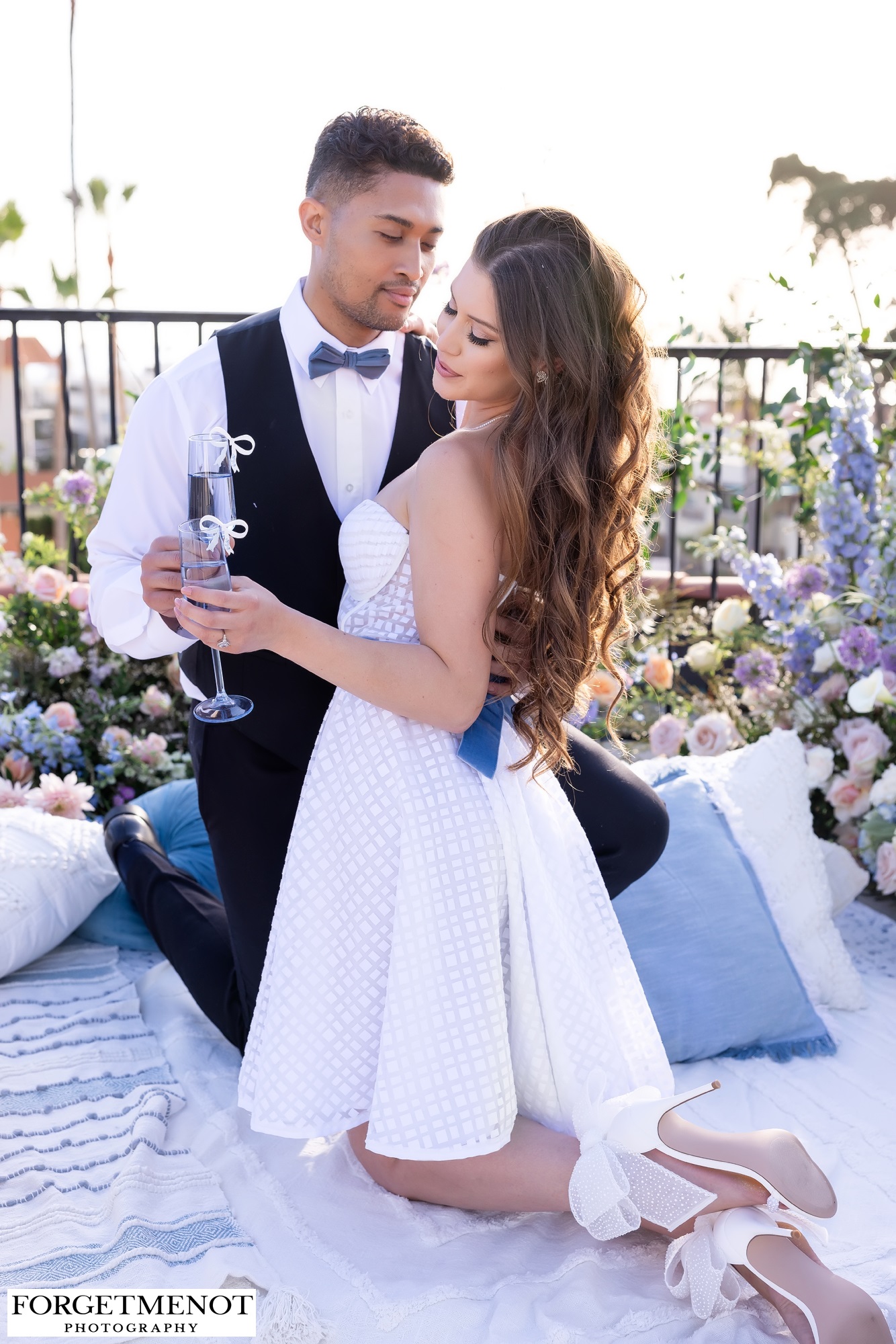 Bride and groom drinking champagne on ocean view terrace