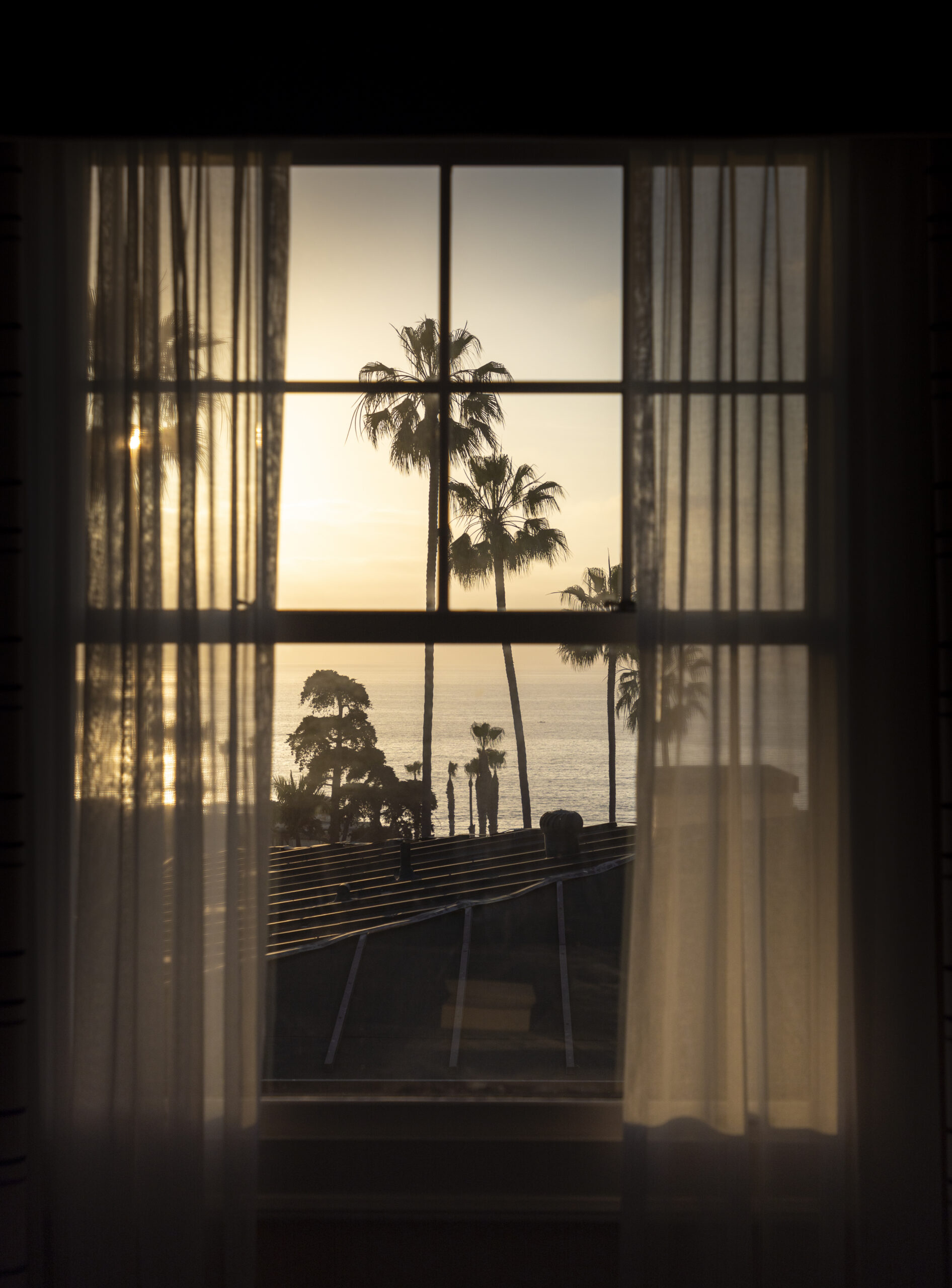 black and white photo of window with view of ocean